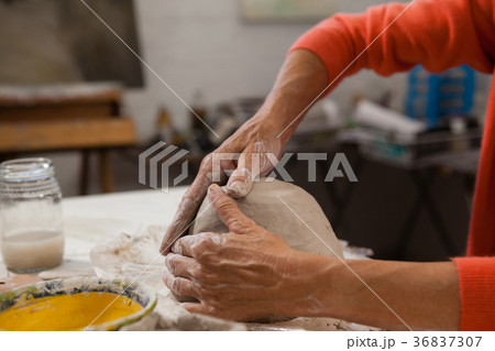 Mid-section of senior woman molding clay Mid-section of senior woman molding clay 36837307