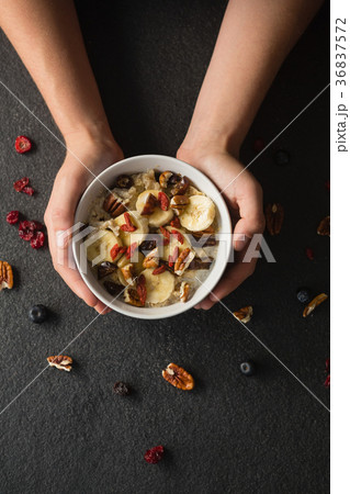 Hands holding a bowl of fruit cereal  36837572