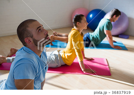 Instructor with students practicing cobra pose in studio 36837919