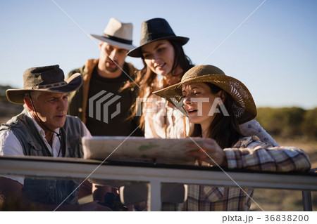 Friends looking at map in vehicle 36838200