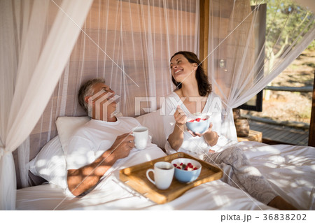 Happy couple having breakfast in canopy bed 36838202