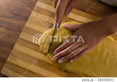 Woman slicing dough on chopping board Woman slicing dough on chopping board 36838831