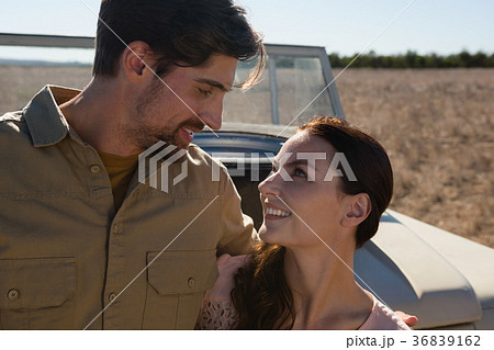 Couple by off road vehicle looking at each other 36839162