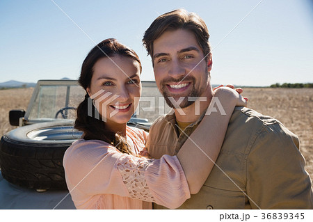 Portrait of smiling couple by off road vehicle 36839345