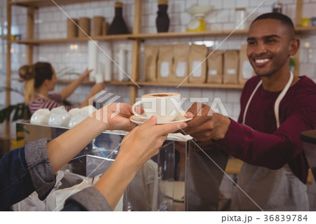 Cropped hands of customer receiving coffee from owner 36839784