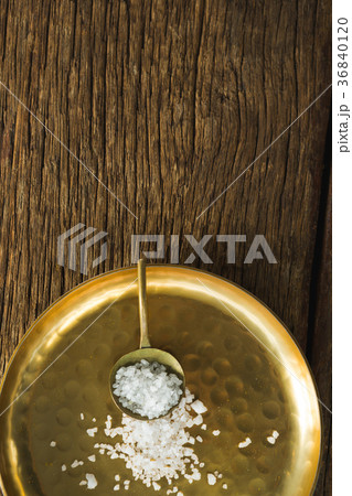 Salt in spoon and plate on wooden table 36840120