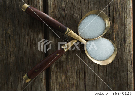 Salt in spoon on wooden table Salt in spoon on wooden table 36840129