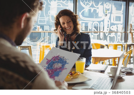 Man holding paper with painting by woman in cafe Man holding paper with painting by woman in cafe 36840503