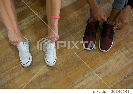 Low section of dancers tying shoelaces Low section of dancers tying shoelaces 36840541