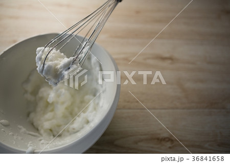 High angle view of wire whisk with whipped cream on bowl 36841658