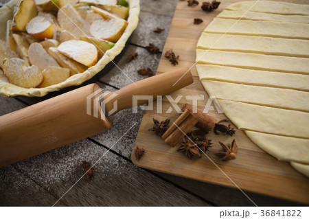 High angle view of pastry dough stripes with spices and apple in baking pan High angle view of pastry dough stripes with spices and apple in baking pan 36841822