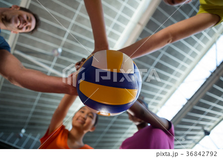 Coach and female players holding volleyball 36842792