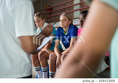 Volleyball coach talking to female players Volleyball coach talking to female players 36842888