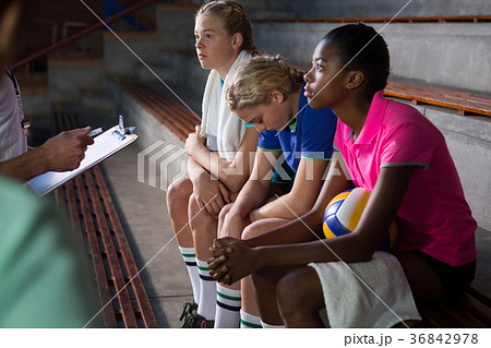 Volleyball coach talking to female players 36842978