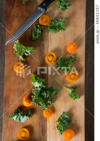 Kale with tomato slices on cutting board 36843167