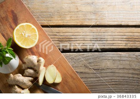 Overhead view of ginger with lemon on cutting board over table Overhead view of ginger with lemon on cutting board over table 36843335