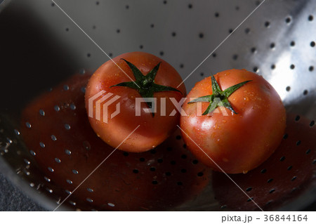 Fresh wet tomatoes in strainer 36844164