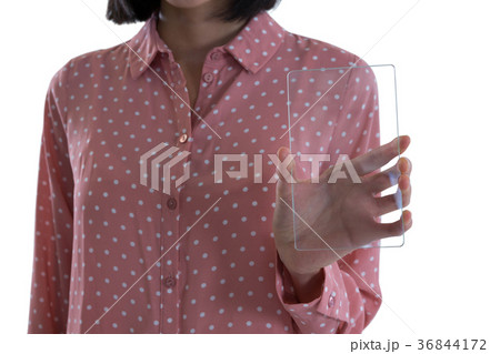 Mid section of female executive holding a glass smartphone 36844172