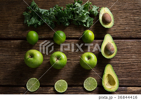 Mustard greens, lemon, avocado and green apple arranged on wooden table 36844416