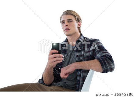 Businessman photographing while sitting on chair 36845396