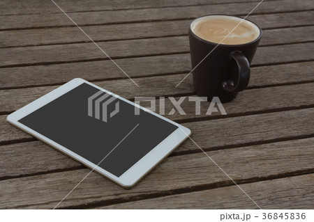 Digital tablet and cup of coffee on wooden plank Digital tablet and cup of coffee on wooden plank 36845836