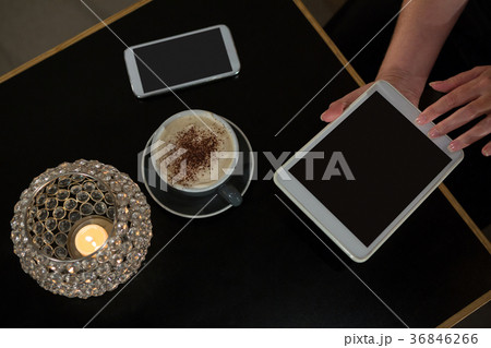 Overhead of woman using digital tablet while having coffee Overhead of woman using digital tablet while having coffee 36846266