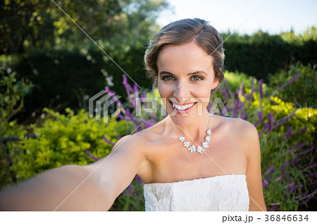 Portrait of smiling beautiful bride standing in yard 36846634