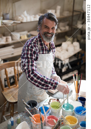 Portrait of male potter holding color tube Portrait of male potter holding color tube 36847112