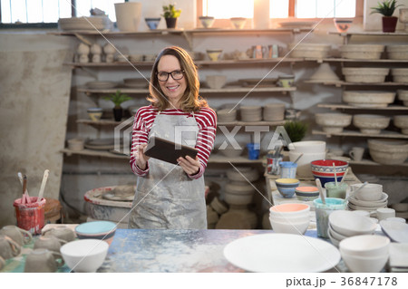 Portrait of female potter using digital tablet 36847178