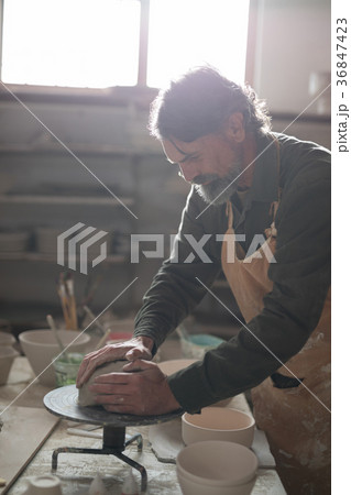 Male potter molding a clay 36847423