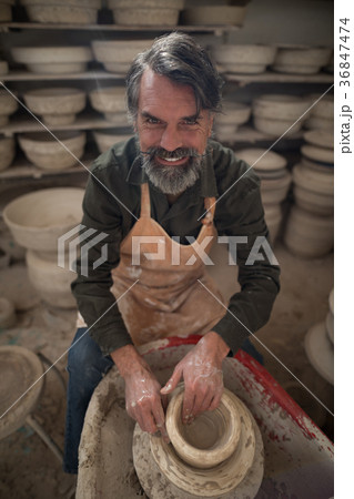 Portrait of male potter molding a clay Portrait of male potter molding a clay 36847474