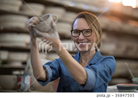 Portrait of female potter making cup Portrait of female potter making cup 36847505