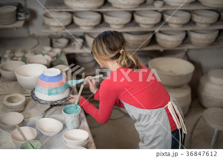 Female potter painting bowl 36847612