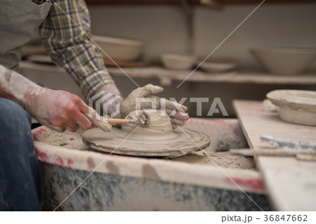 Mid section of male potter molding plate with hand tool Mid section of male potter molding plate with hand tool 36847662