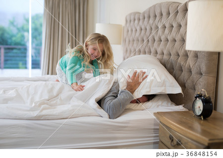 Father and daughter having fun on bed Father and daughter having fun on bed 36848154