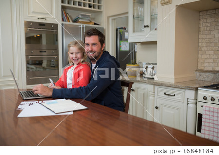 Father and daughter working on laptop at home Father and daughter working on laptop at home 36848184