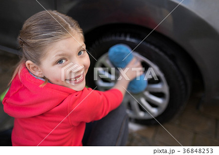 Teenage girl washing a car on a sunny day Teenage girl washing a car on a sunny day 36848253