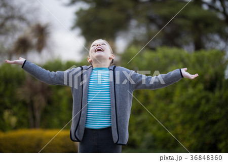 Girl standing in the park with arms wide open Girl standing in the park with arms wide open 36848360