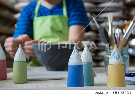 Paint tubes on worktop while boy painting a bowl Paint tubes on worktop while boy painting a bowl 36848415