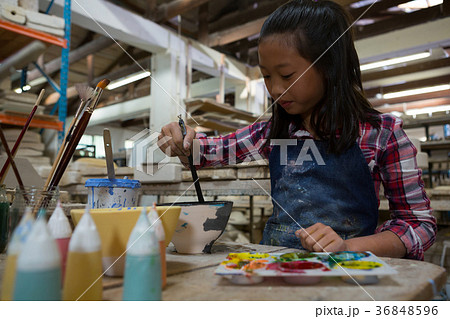 Attentive girl painting a bowl 36848596