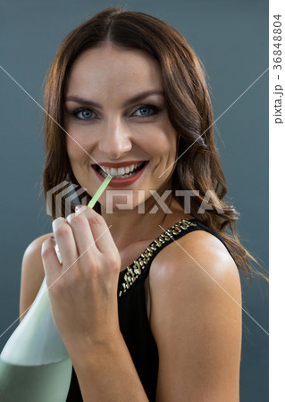 Woman drinking champagne with straw 36848804
