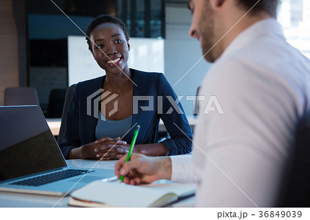 Female executive interacting with her colleague at desk 36849039