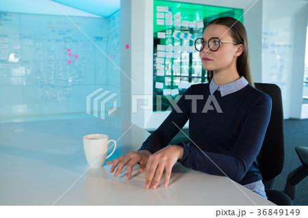 Female executive gesturing at desk 36849149