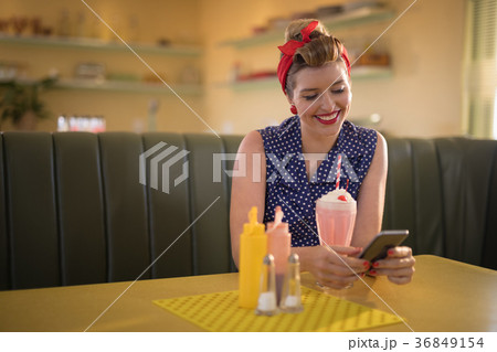 Woman using mobile phone in restaurant 36849154
