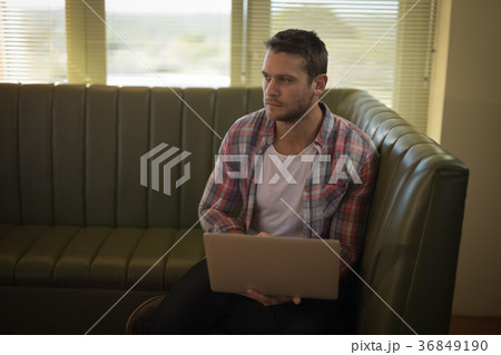 Man using laptop in restaurant 36849190