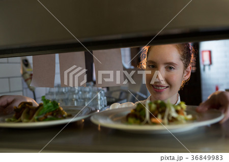 Female chef reading order in the kitchen 36849983
