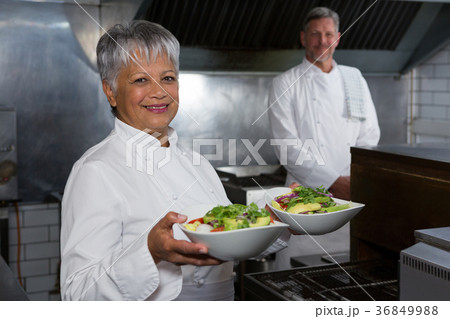 Female chef holding food plate 36849988
