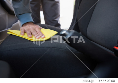 Worker cleaning seat inside the car Worker cleaning seat inside the car 36850168
