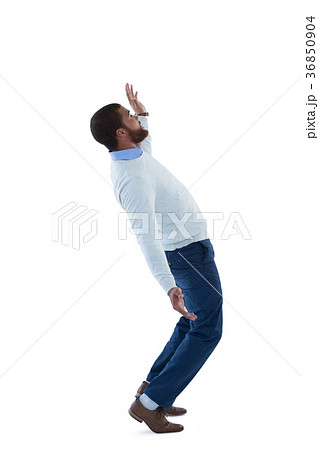 Male executive balancing while walking against white background 36850904