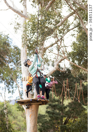 Woman enjoying zip line adventure in park Woman enjoying zip line adventure in park 36851137